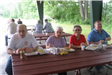 Four Seniors Eating at Picnic Table