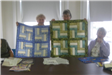 Women Holding Blue and Green Quilts
