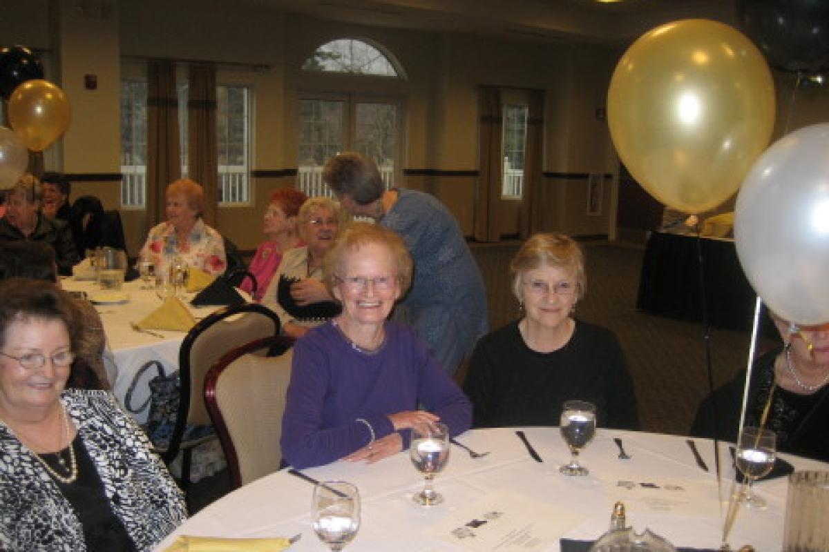 Women Sitting and Smiling at a Table