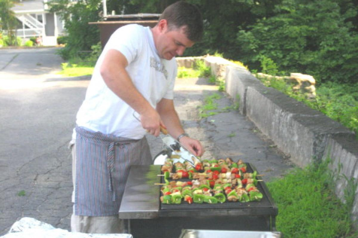 Person Grilling Kebabs