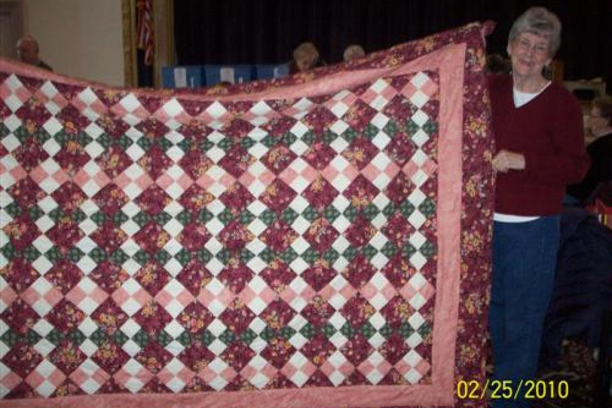 Woman Holding Red, and White Quilt