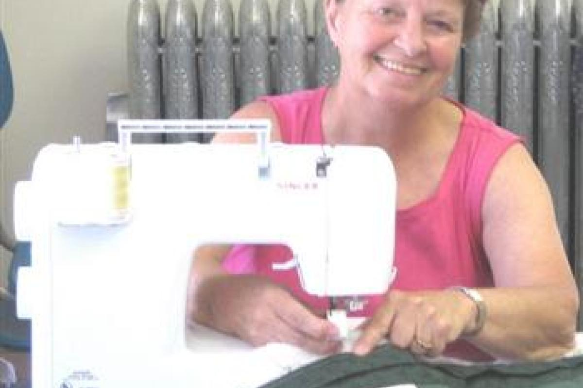 Woman Smiling While Using Sewing Machine