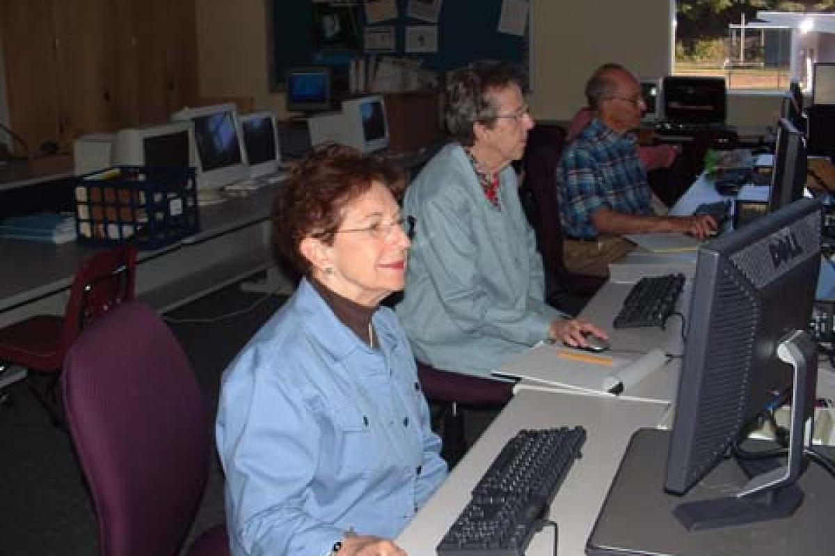 Three People Sitting at Computers
