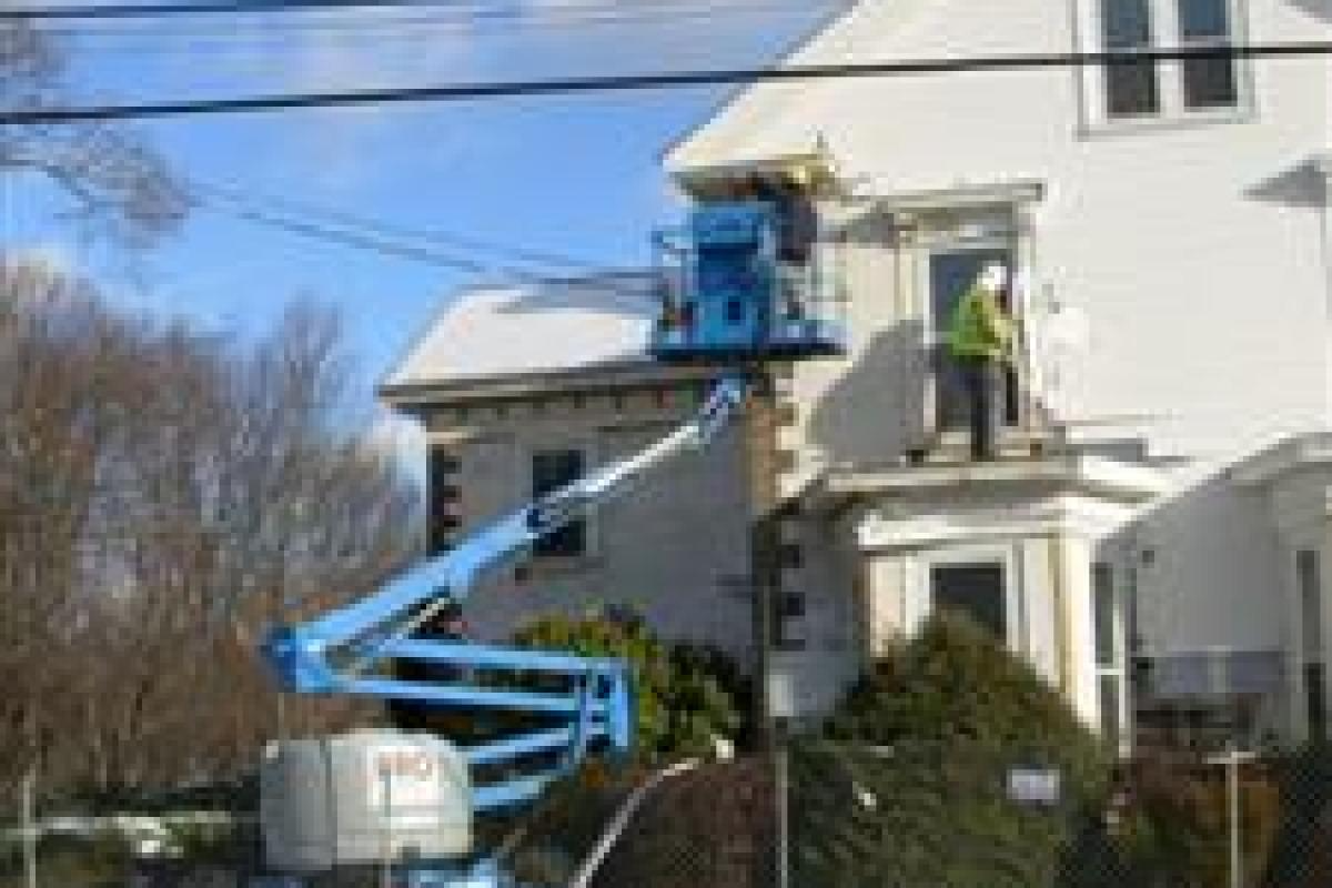 Crane Next to Person on the Roof